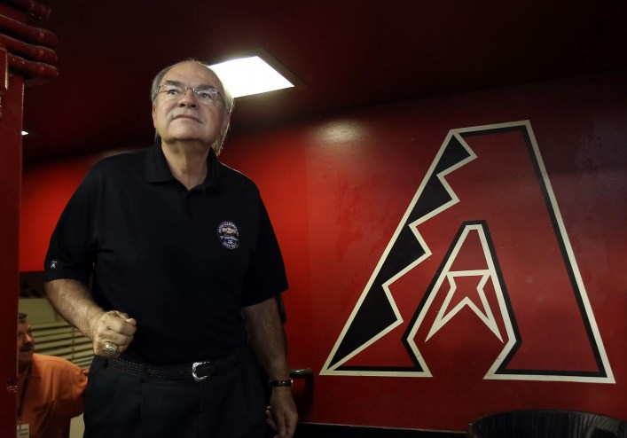 Arizona Diamondbacks owner Ken Kendrick, standing in front of a large Diamondbacks "A" logo.