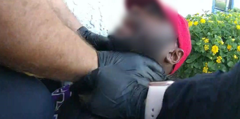 Body-cam footage of a gloved police officer choking someone whose face is blurred