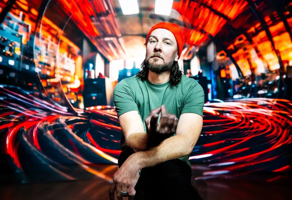 A man wearing a green shirt and red cap looking at the camera.