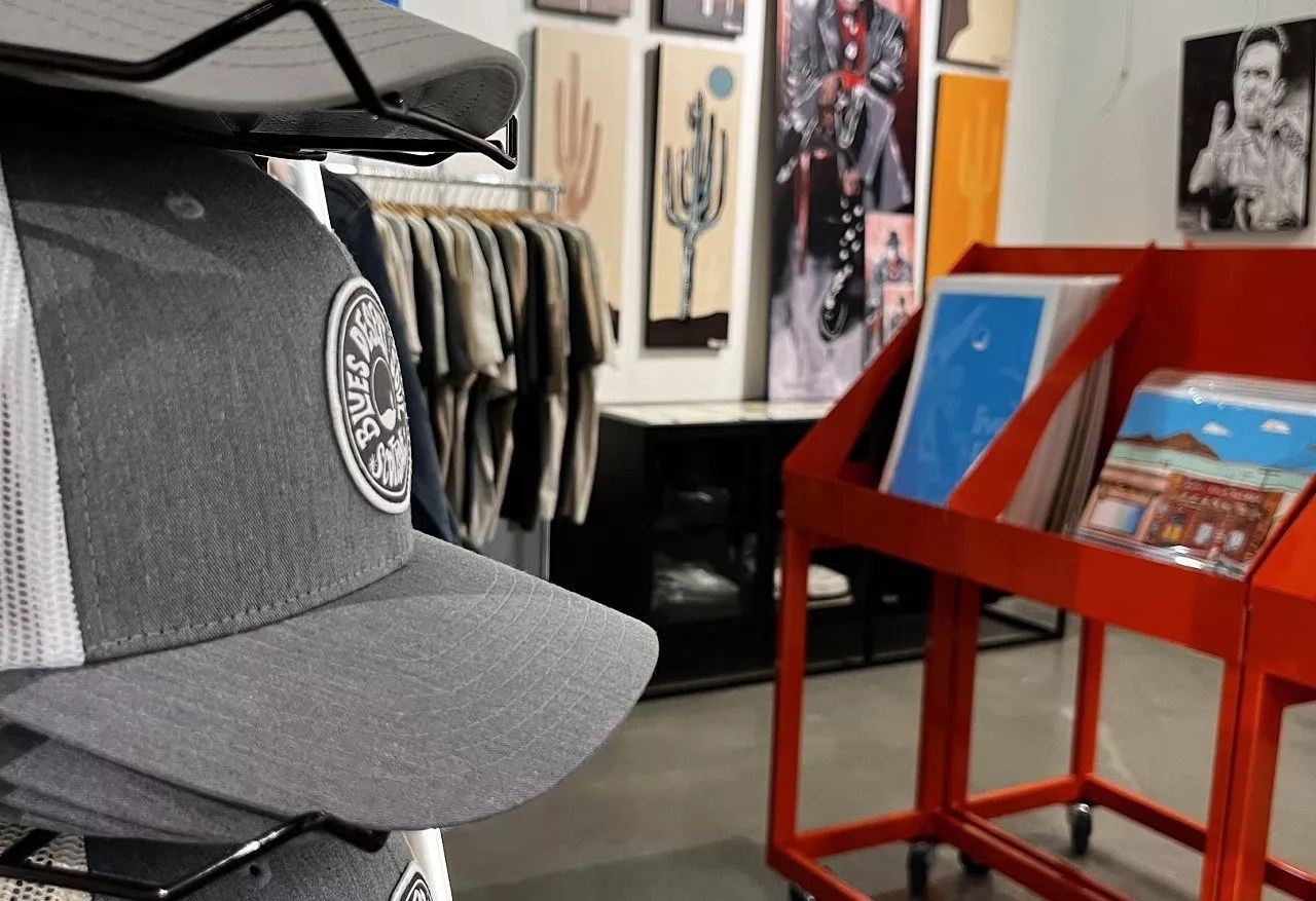 A store with a hat in the foreground and art on the walls.