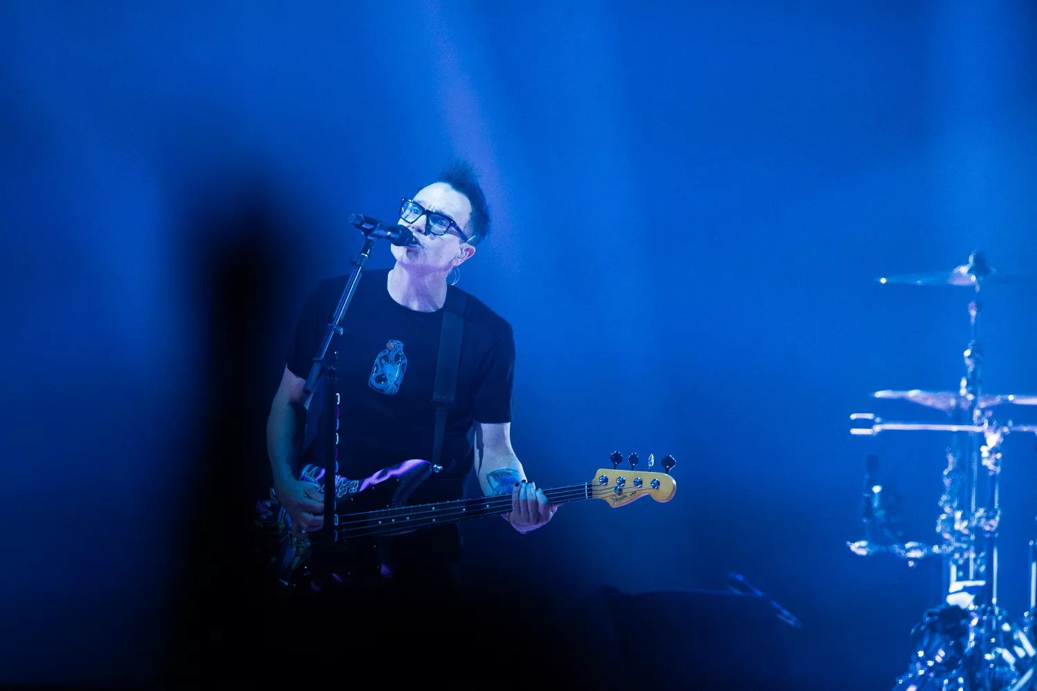 A man singing and playing bass.