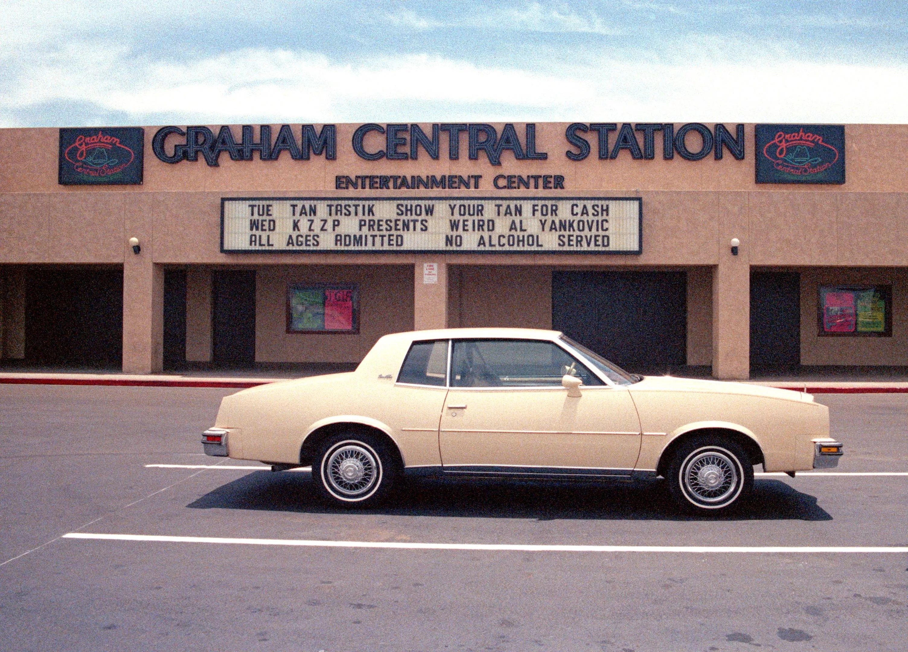 Exterior photo of a nightclub with a car parked in front.