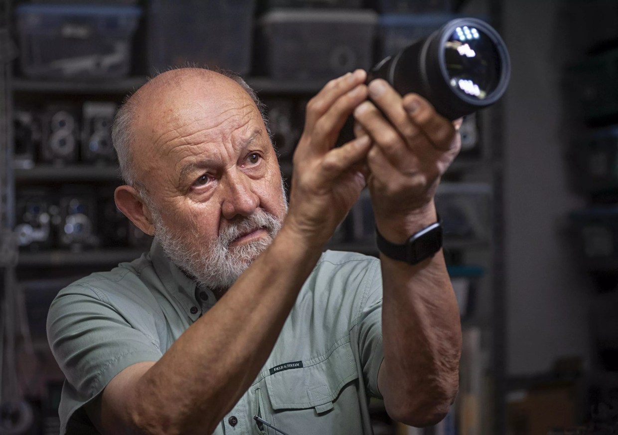 A man looking through a camera.