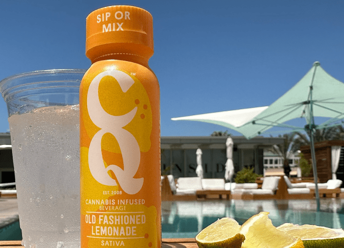 a bottle of CQ's "old fashioned lemonade" next to a pool on a summer day