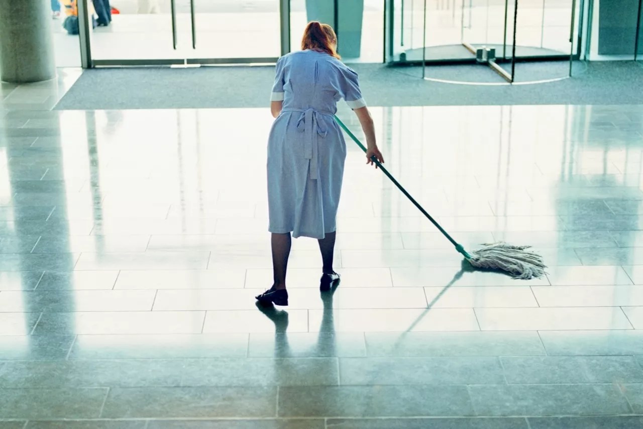 A hotel housekeeper mopping a lobby floor