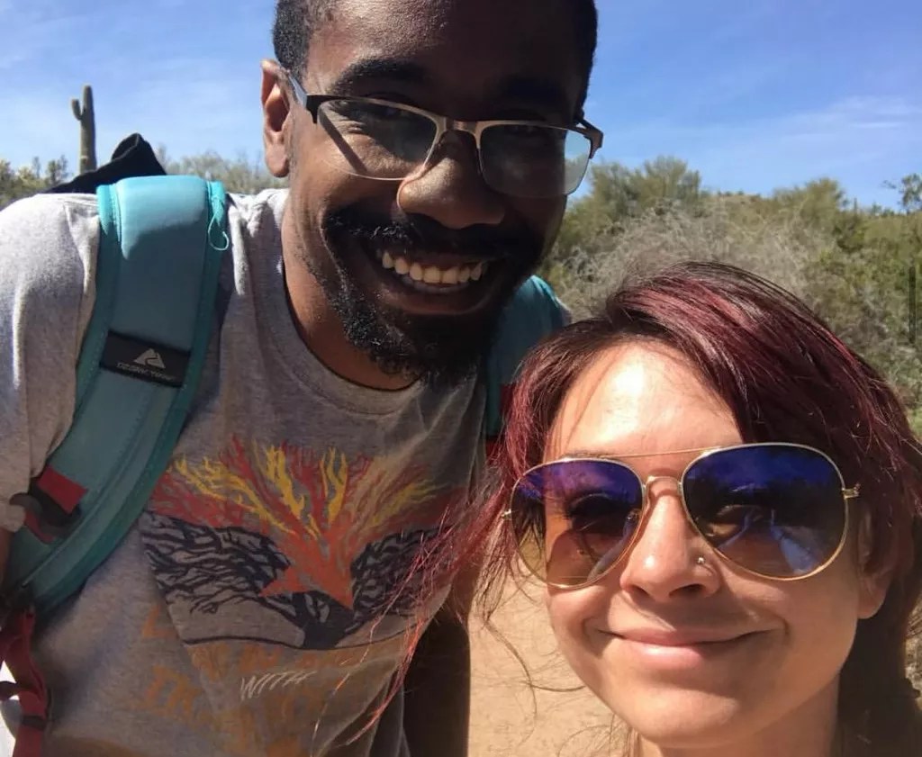 a man and woman pose for a selfie outdoors