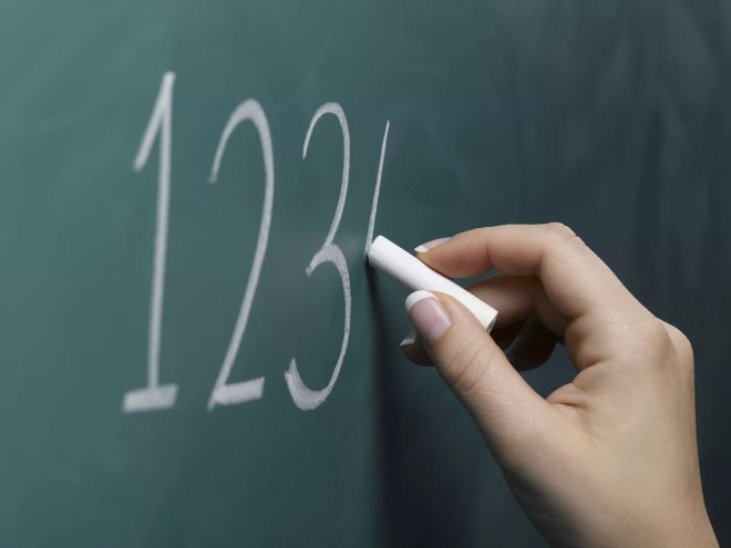 a hand writing 1-2-3-4 on a chalkboard