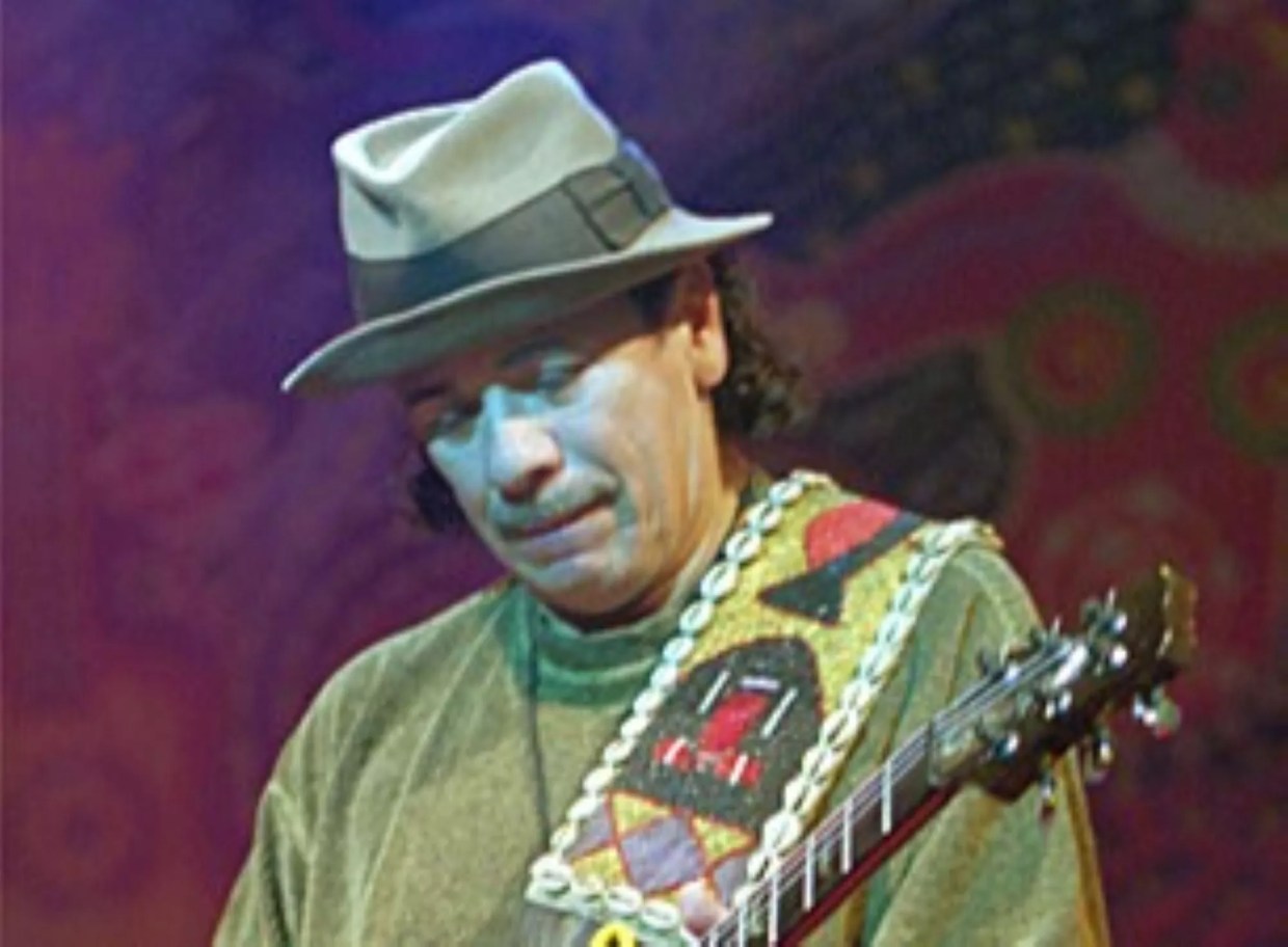 A man in a hat playing guitar.