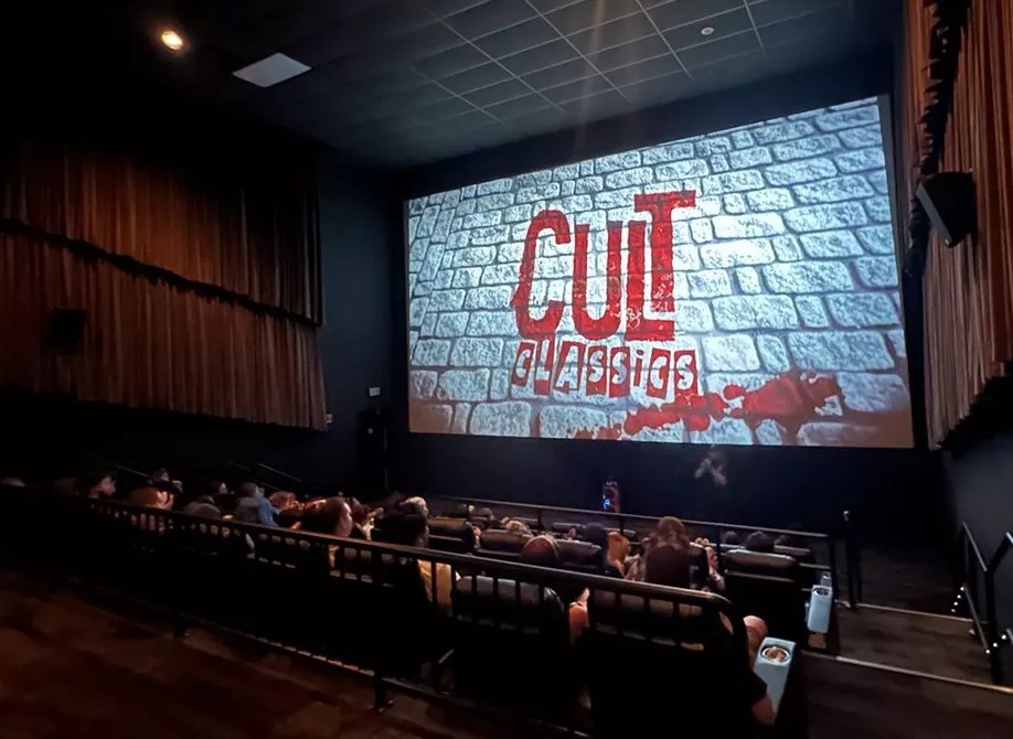 A theater full of people looking at a movie screen.