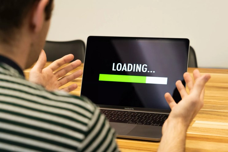 a man frustrated at a computer with a loading bar on it