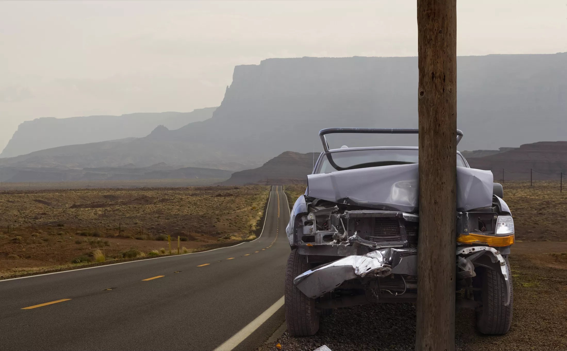a car crashed into a pole on a remote desert road