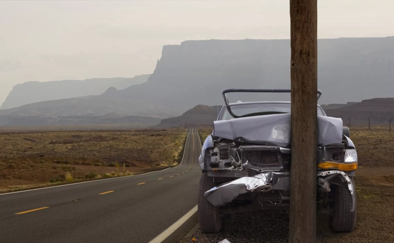 a car crashed into a pole on a remote desert road