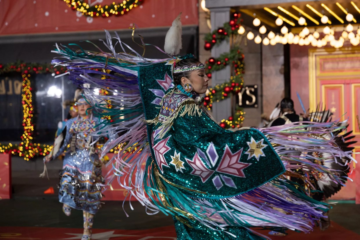 A Native American woman performs a dance.