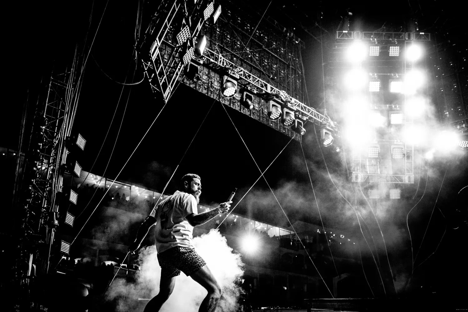 A black and white photo of a man singing at  concert.