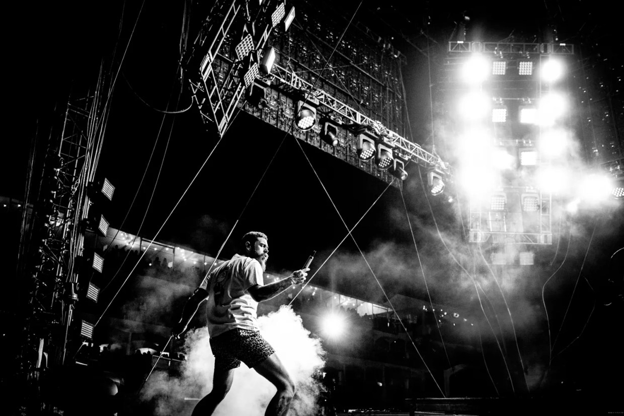 A black and white photo of a man singing at  concert.