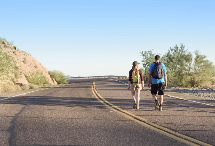 two people walking on an arizona road