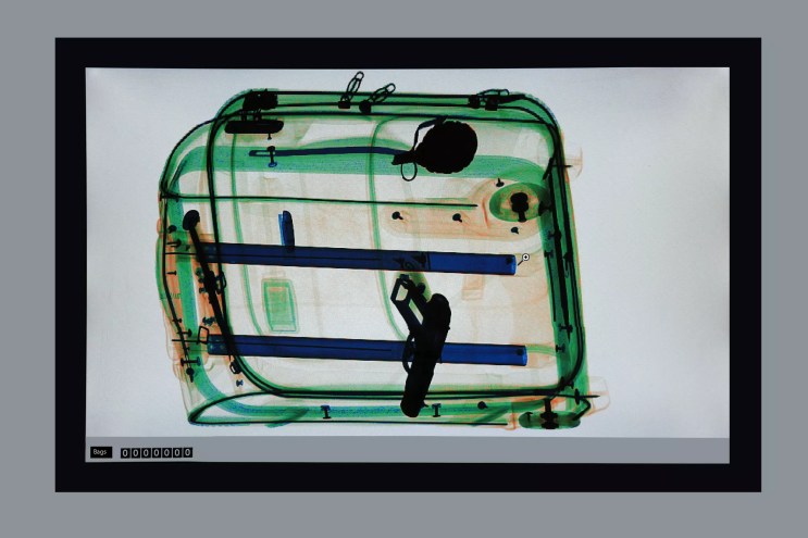 an x-ray of a suitcase showing a handgun in it