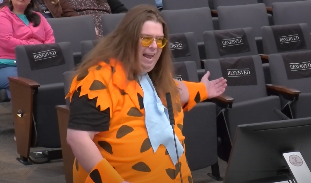 a man dressed as fred flintstone at a podium