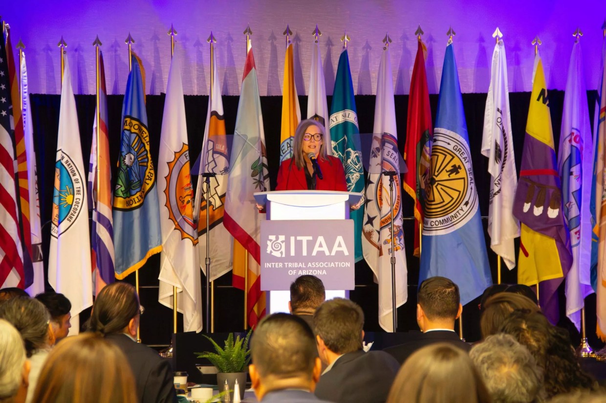 A woman standing in front of a line of flags.