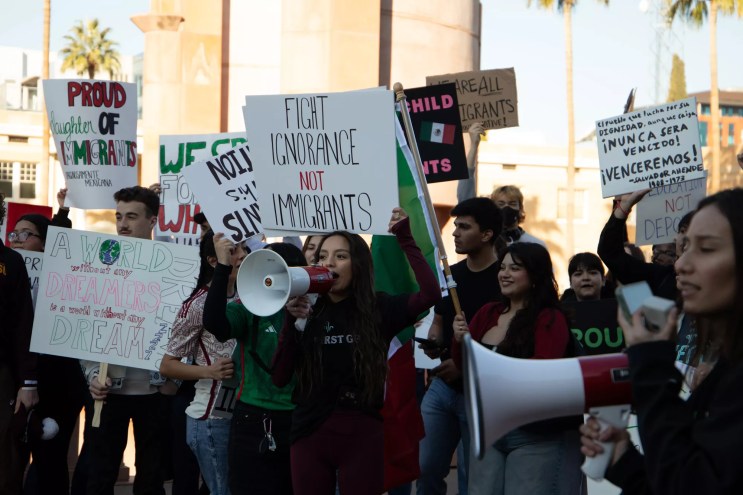 protesters hold up pro-immigrant signs