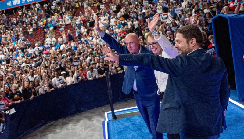 mark kelly, gabby giffords and ruben gallego wave to a crowd
