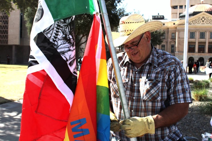 a man strings a flag onto a pole