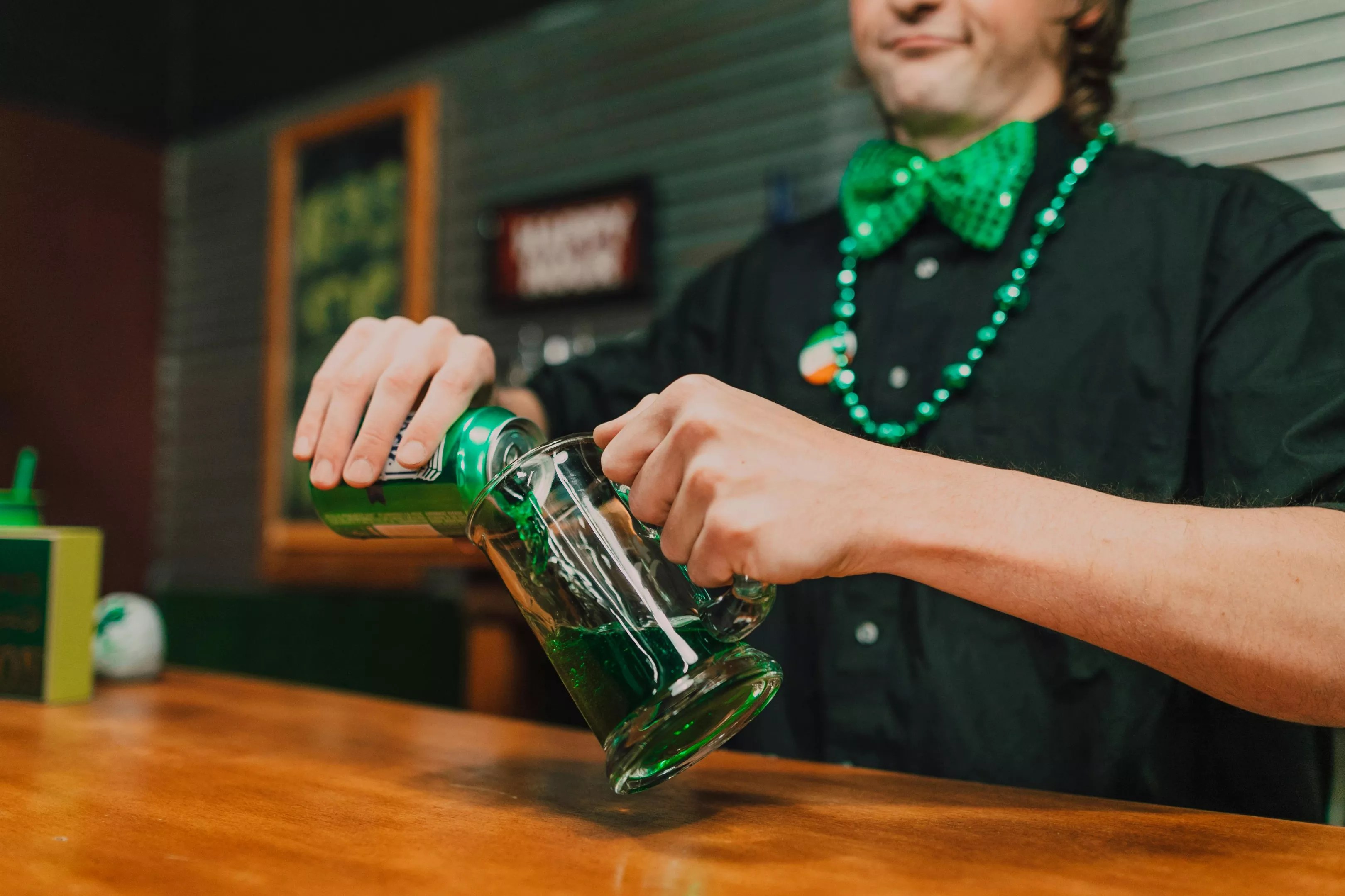A man pouring a green beer.