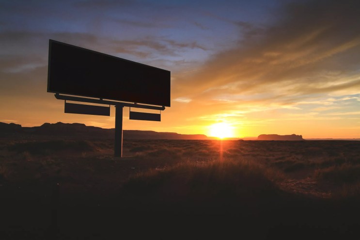 a billboard backlit by an arizona sunset