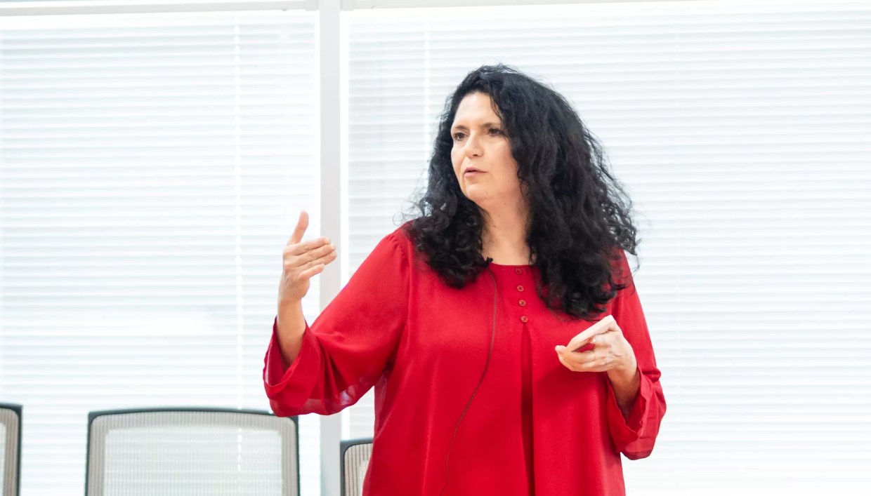 a woman with curly black hair and a red blouse