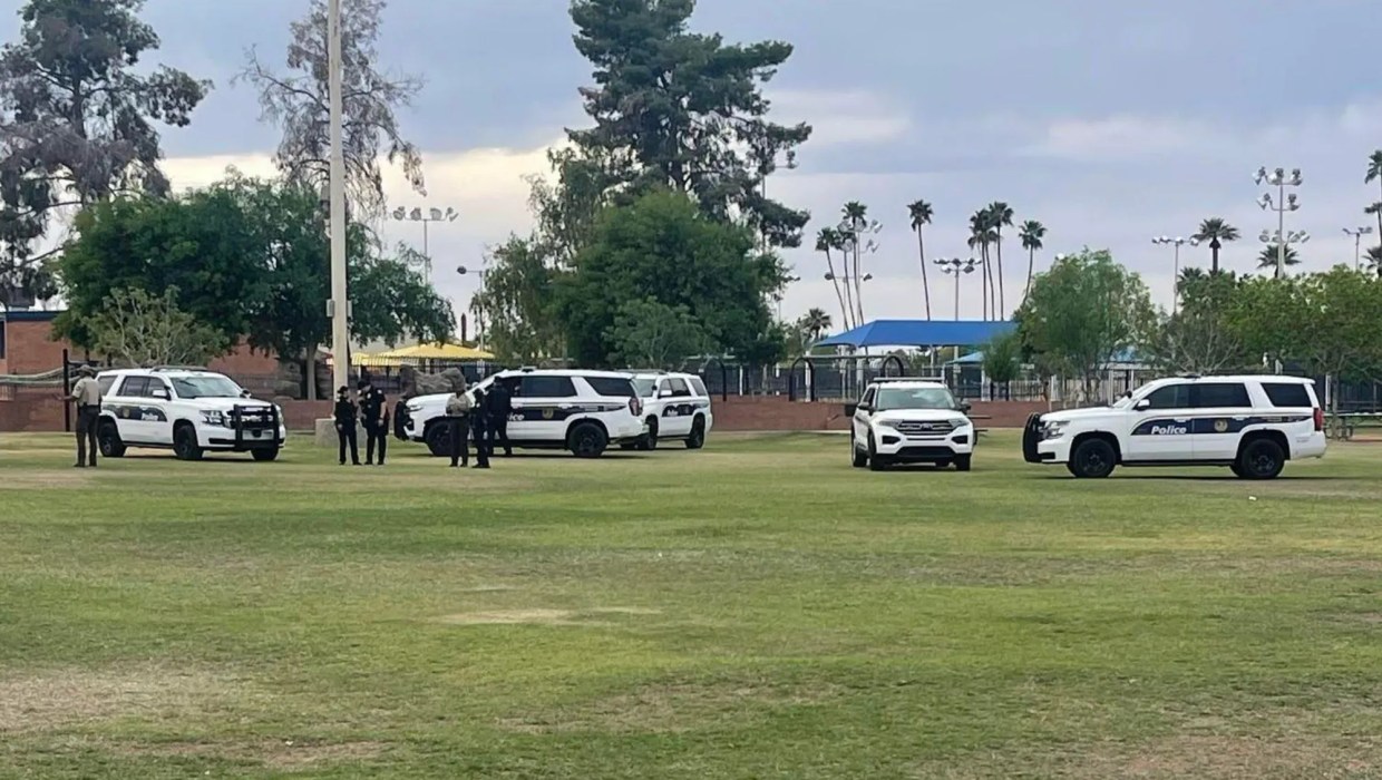 Police officers and vehicles at a park.