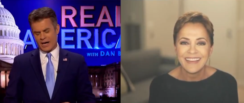 kari lake smiles while on an OAN show