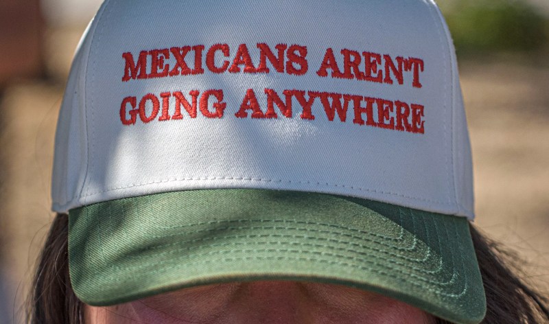 A woman wearing a hat that reads Mexicans Aren't Going Anywhere