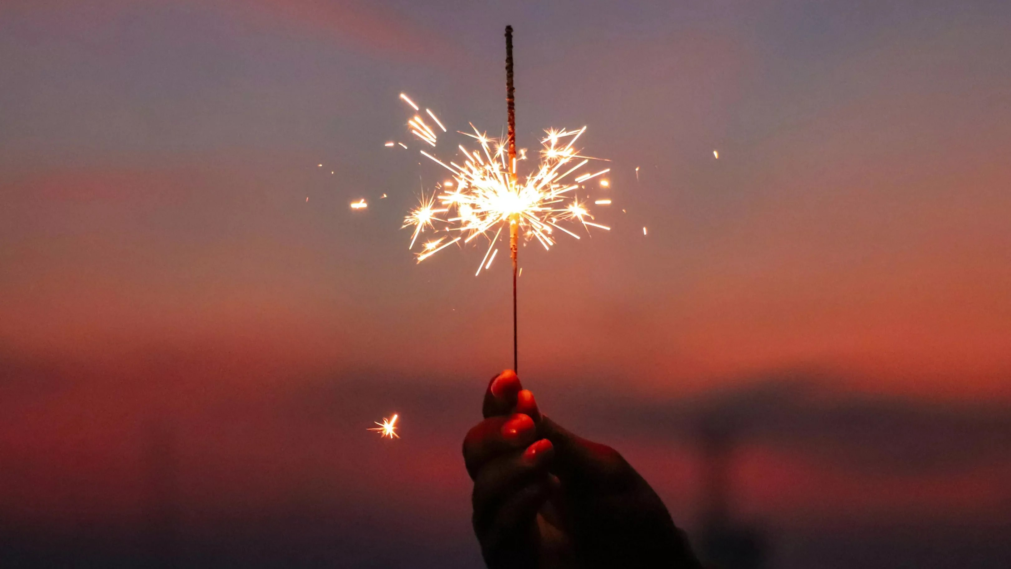 a hand holding a sparkler