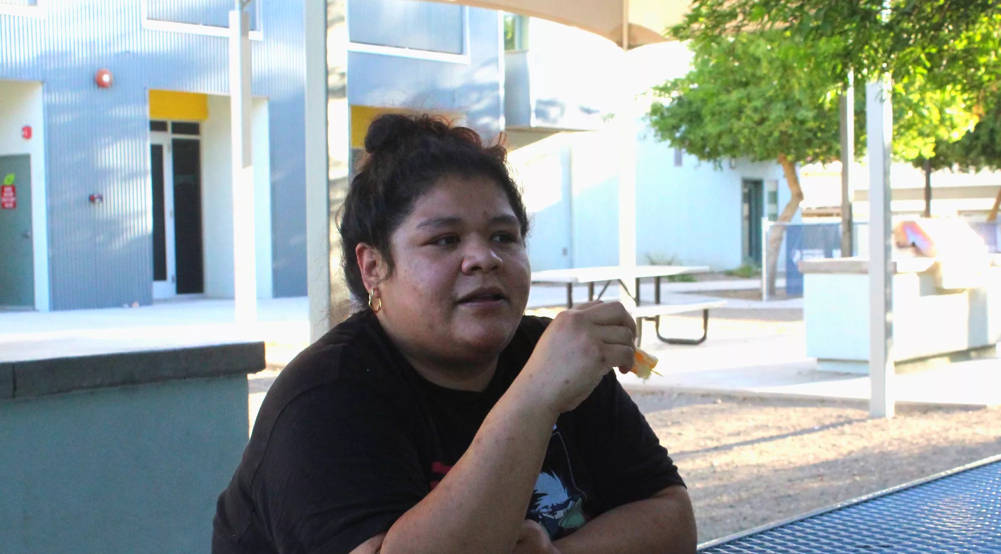 a woman sits at a picnic table