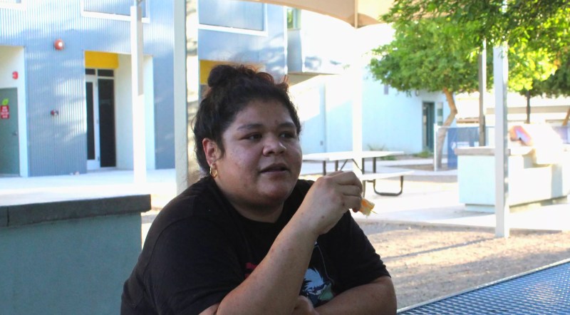 a woman sits at a picnic table