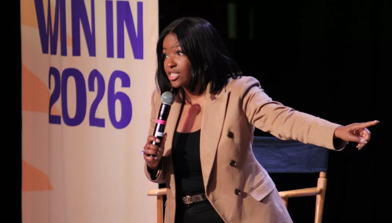 jasmine crockett speaks into a microphone and points off to her side