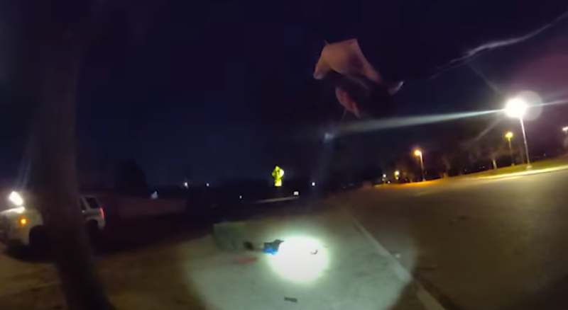 body-cam footage of a person holding a gun on someone laying on the ground